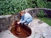 Stephanie drinks from the Chalice Well's Lion Fountain (05/08/99). Click here for full size image.